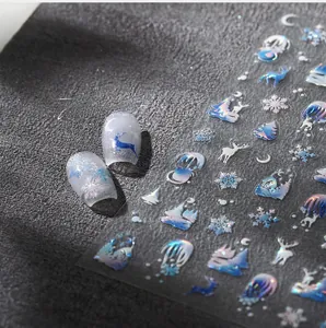 Detailed view of Christmas nail stickers with blue reindeer and aurora snowflake patterns