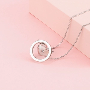 Gros plan détaillé du pendentif cœur en argent avec nacre et diamant central