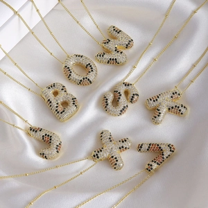 Gold leopard pattern zircon letter pendants on bead chain necklaces with silk background
