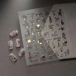Detail of gold foil nail stickers featuring elegant English text and abstract line patterns