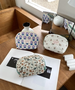 Detailed view of quilted cotton cosmetic bags in purple, red, and autumn floral patterns