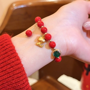 Nahaufnahme eines roten Achat-Perlenarmbands mit goldenem Schlangenanhänger