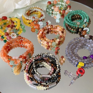 Detailansicht des mehrlagigen Edelstein-Perlenarmbands mit Blumenanhängern und Quasten