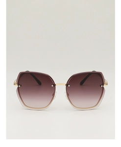 Detail of gradient brown lenses and gold metal frames on oversized rimless sunglasses