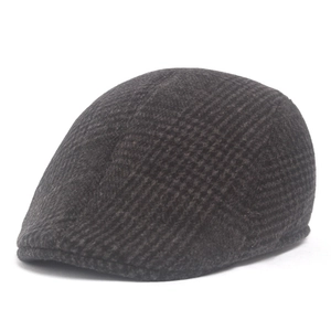 Detailed close-up of dark brown plaid wool blend texture on a classic ivy newsboy cap