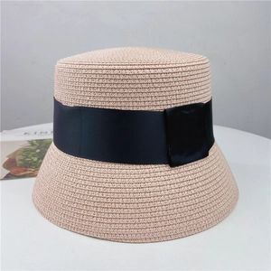 Detailed texture of pink woven straw hat with a wide black grosgrain ribbon accent
