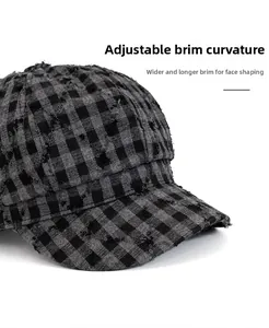 Dettaglio del cappello a quadri con bordo sfrangiato e visiera ampia modellabile per il viso