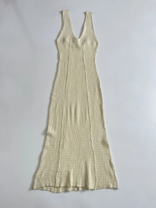 Detaillierte Nahaufnahme der cremefarbenen Strickstruktur eines ärmellosen Midi-Kleids