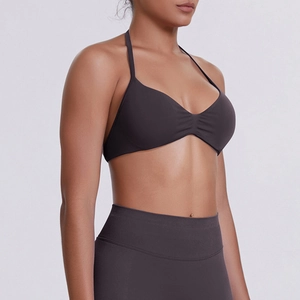 Detail view of seamless dark grey halter neck sports bra with ruched chest design