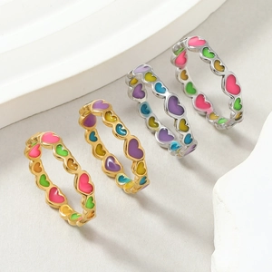 Detailed view of colorful enamel heart rings in gold and silver stainless steel plating