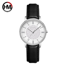 Detail of silver watch bezel with small crystals and black leather strap for women