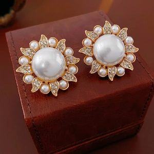 Luxury floral pearl stud earrings with sparkling crystals on a vintage leather box