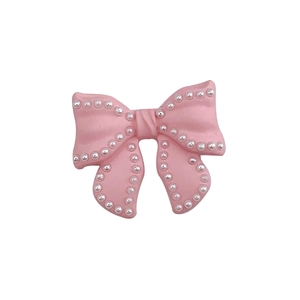 Pink spray-painted bow accessory with white faux pearl trim for DIY phone case crafts