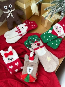 Close-up of festive coral fleece Christmas socks with 3D cartoon animal characters