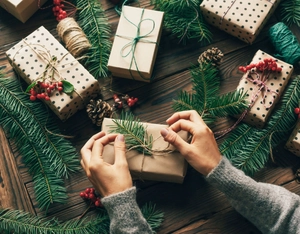 Close-up of Christmas gift wrapping with natural pine needles, pine cones and red berries