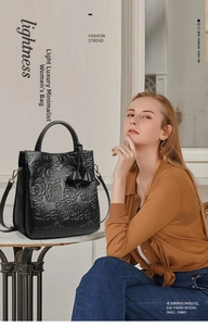 Dettaglio borsa in pelle nera con goffratura rose 3D e ganci metallici laterali