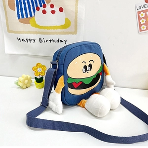 Close-up of a blue canvas burger-shaped crossbody bag with creative 3D plush arms and legs