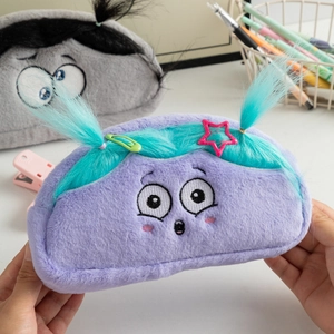 Close-up of cute purple plush pencil case with funny hair and embroidered big eyes