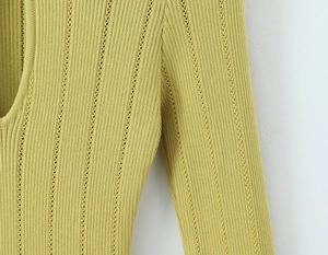 Détail de la robe en maille verte avec texture côtelée ajourée et couture d'épaule