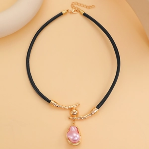 Dettaglio del ciondolo con perla barocca rosa e cornice dorata su cordoncino in cuoio nero
