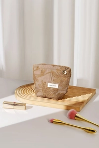 Detail of floral embroidery on beige cotton linen makeup bag with flower zipper pull