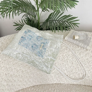 Close-up of light green velvet tote bag with lace detail and vintage floral pocket