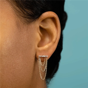 Detail of triple-layered chain tassel earrings with sparkling crystals on gold plating