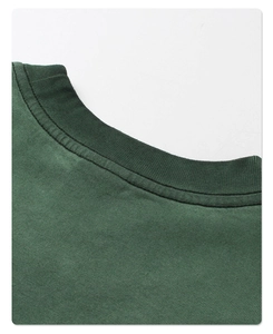 Detailed macro view of the ribbed round neckline and double stitching on vintage green tee