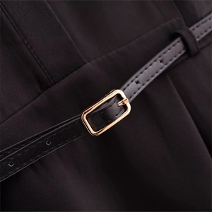 Chic black long-sleeved dress featuring a slim faux leather belt with a gold metal buckle