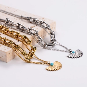 Double layer necklace with fan pendant and turquoise bead in gold and silver finish