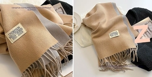 Detail of soft cashmere-like scarf with fringe edges and contrasting color block design