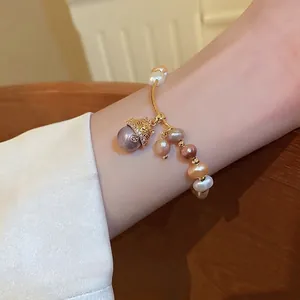 French vintage freshwater pearl bracelet with a gold lucky cat zircon charm on wrist