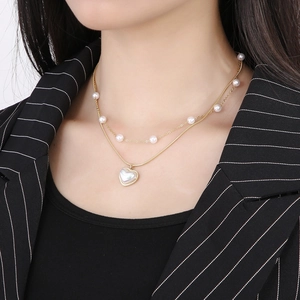Double-layered gold-plated heart necklace with pearls and snake chain on model