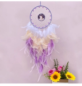 Detailed view of purple dream catcher with tree of life crystal stone and feathers