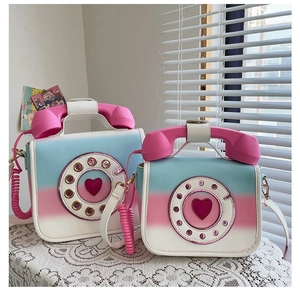 Detail view of two gradient telephone-shaped creative PU leather crossbody bags side by side