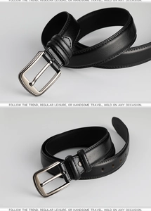 Close-up of black leather belt with brushed silver pin buckle and detailed stitching