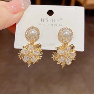 Detail of S925 silver needle earrings with golden sunburst zircon and pearl design