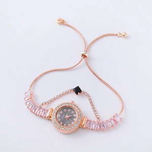 Detail of rose gold bracelet watch with pink rectangular gems and a black square dial