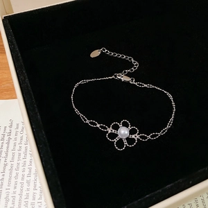 Detail view of silver flower bracelet with a white pearl in a black velvet jewelry box