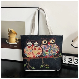 Detailed embroidery of colorful owls on a large black canvas tote bag for women