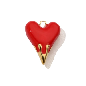 Dettaglio macro del ciondolo a cuore vintage con smalto rosso e texture oro fuso