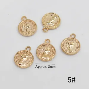 Detailed view of 8mm golden alloy coin charms with Elizabeth II relief for DIY nail art
