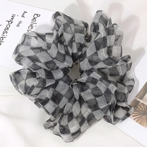 Detailed view of black and white checkerboard organza hair scrunchie with sheer texture