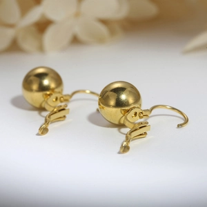 Elegant gold spherical lever-back earrings featuring a minimalist polished steel finish