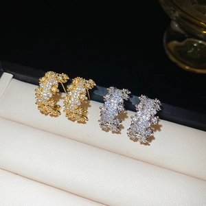 Macro shot of gold and silver C-shaped earrings with shimmering pave-set cubic zirconia