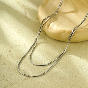 Vue détaillée du collier double chaîne serpent argentée avec texture métallique polie