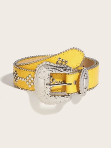 Detail of yellow crocodile embossed belt with silver floral buckle and western studs