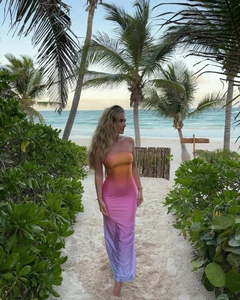Detail eines sexy Bodycon-Maxikleides mit Sonnenuntergang-Farbverlauf vor Strandkulisse