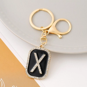 Luxury gold letter X keychain with black enamel and sparkling rhinestones on the pendant