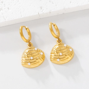 Golden hoop earrings with shell pendant and white pearls on minimalist background
